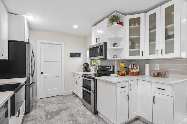 a kitchen with white cabinets and stainless steel appliances