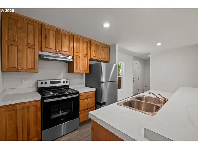 a kitchen with stainless steel appliances granite countertop a refrigerator stove and sink