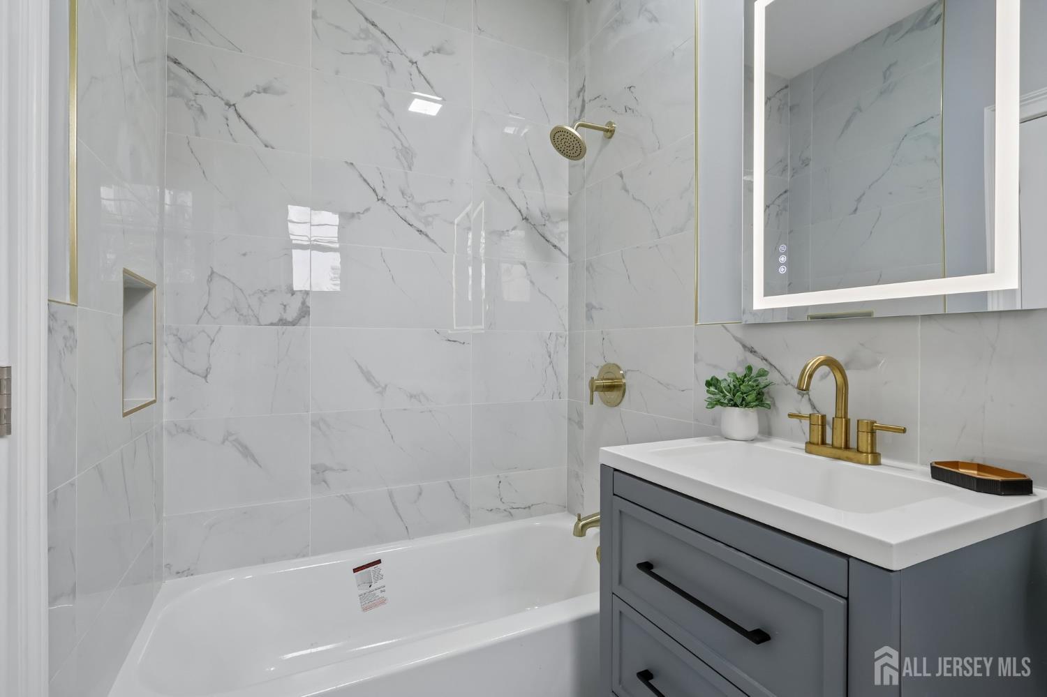 239 Suttons Lane Edison, NJ 08817 - Photo 29 of 68 a bathroom with a sink a bathtub and a shower