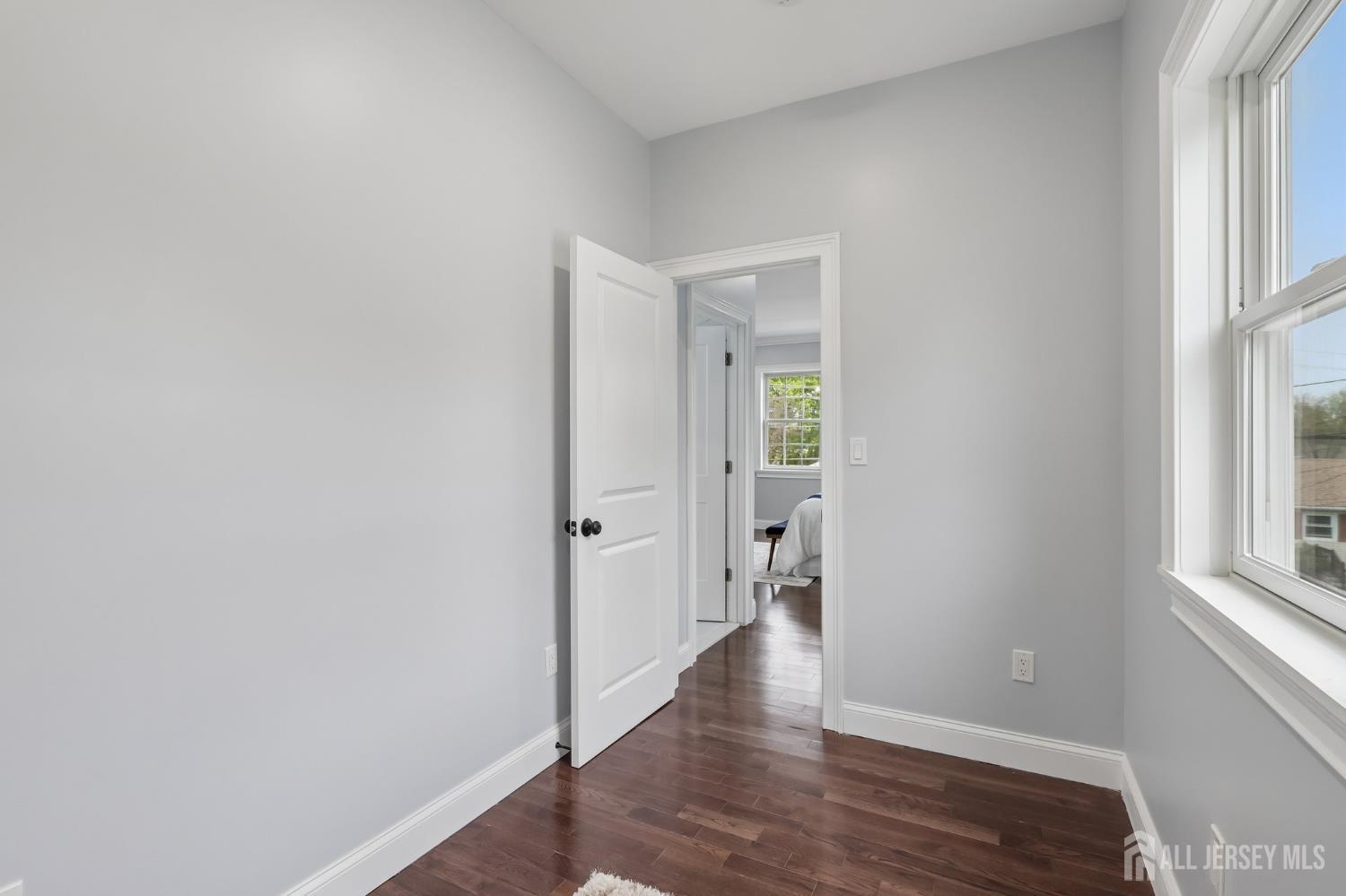 239 Suttons Lane Edison, NJ 08817 - Photo 42 of 68 a view of an empty room with wooden floor and a window