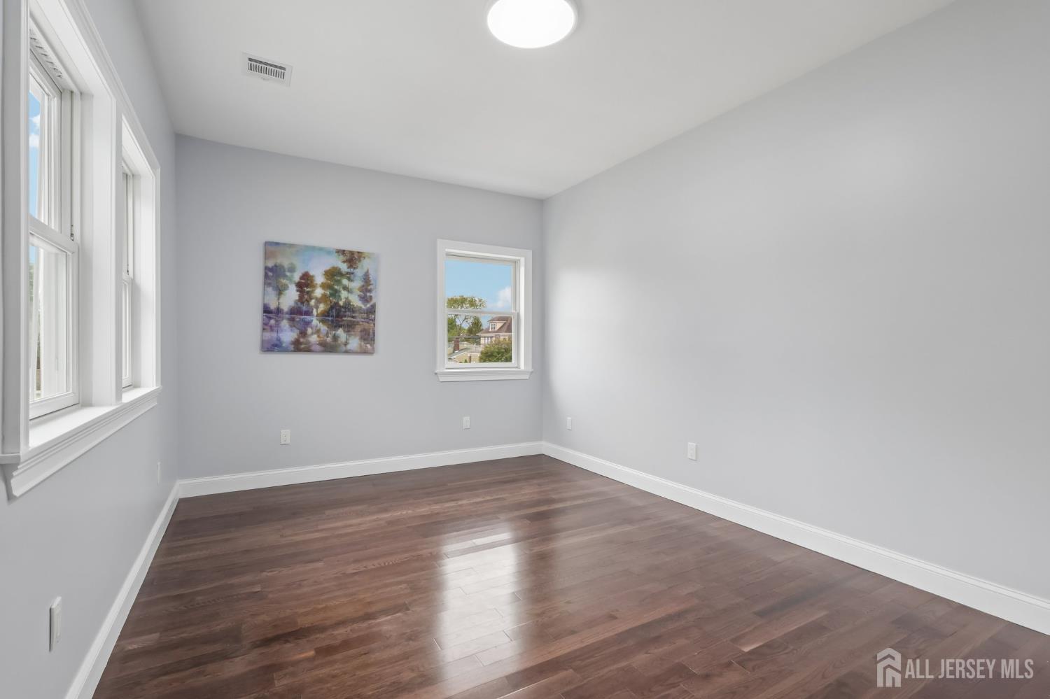 239 Suttons Lane Edison, NJ 08817 - Photo 49 of 68 wooden floor in an empty room with a window