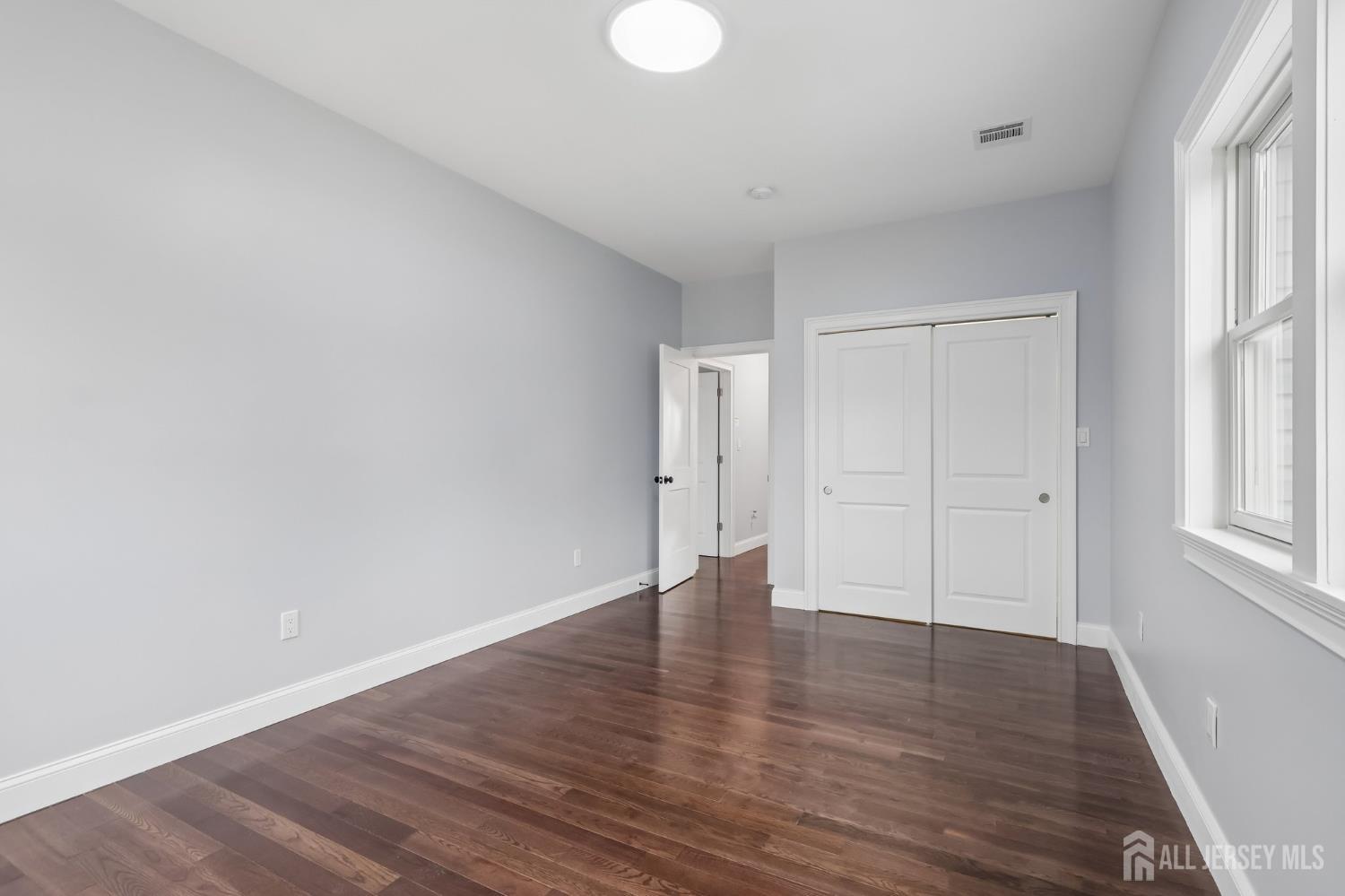 239 Suttons Lane Edison, NJ 08817 - Photo 50 of 68 a view of an empty room with wooden floor and a window