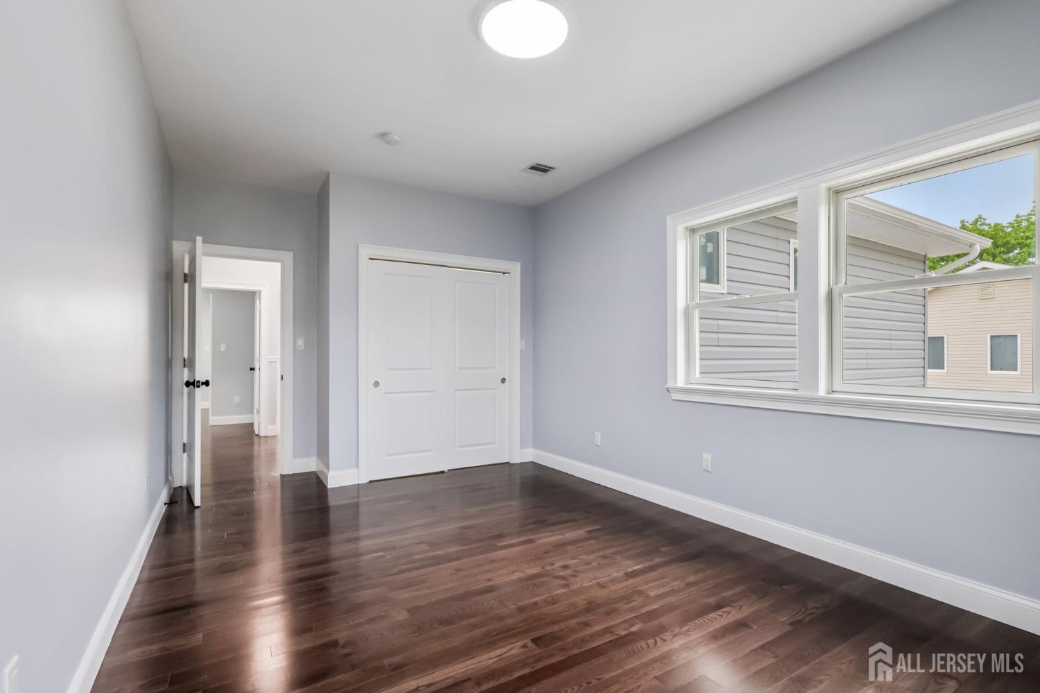 239 Suttons Lane Edison, NJ 08817 - Photo 51 of 68 a view of an empty room with wooden floor and a window