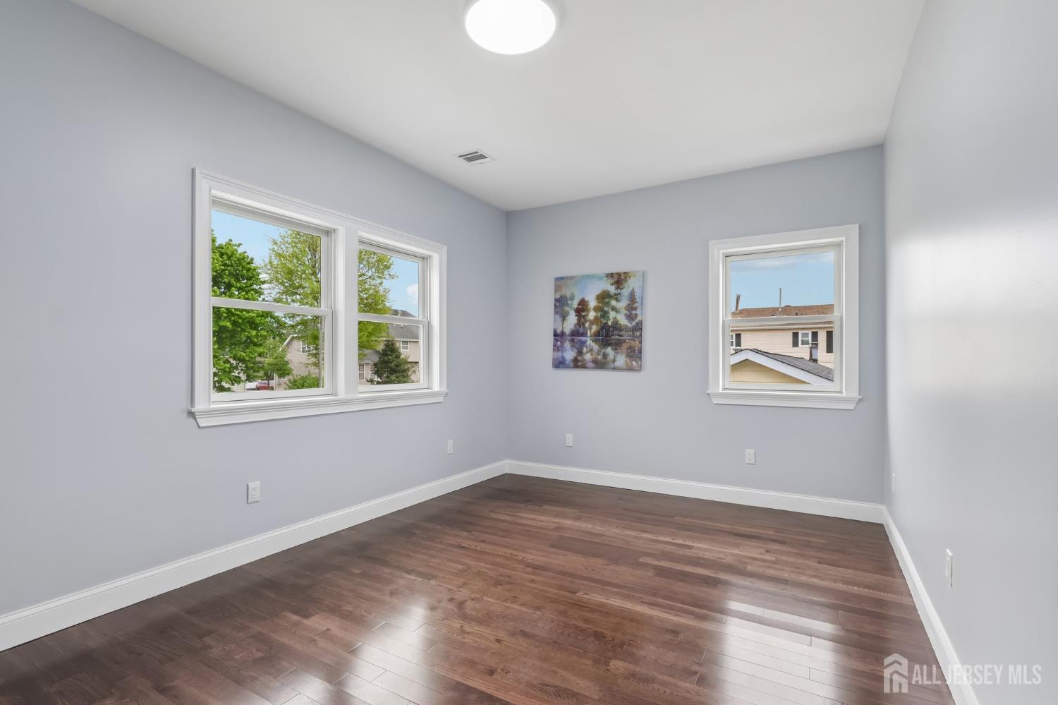 239 Suttons Lane Edison, NJ 08817 - Photo 52 of 68 a view of an empty room with a window and wooden floor