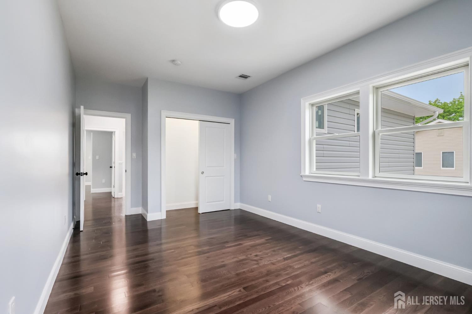 239 Suttons Lane Edison, NJ 08817 - Photo 53 of 68 a view of an empty room with wooden floor and a window