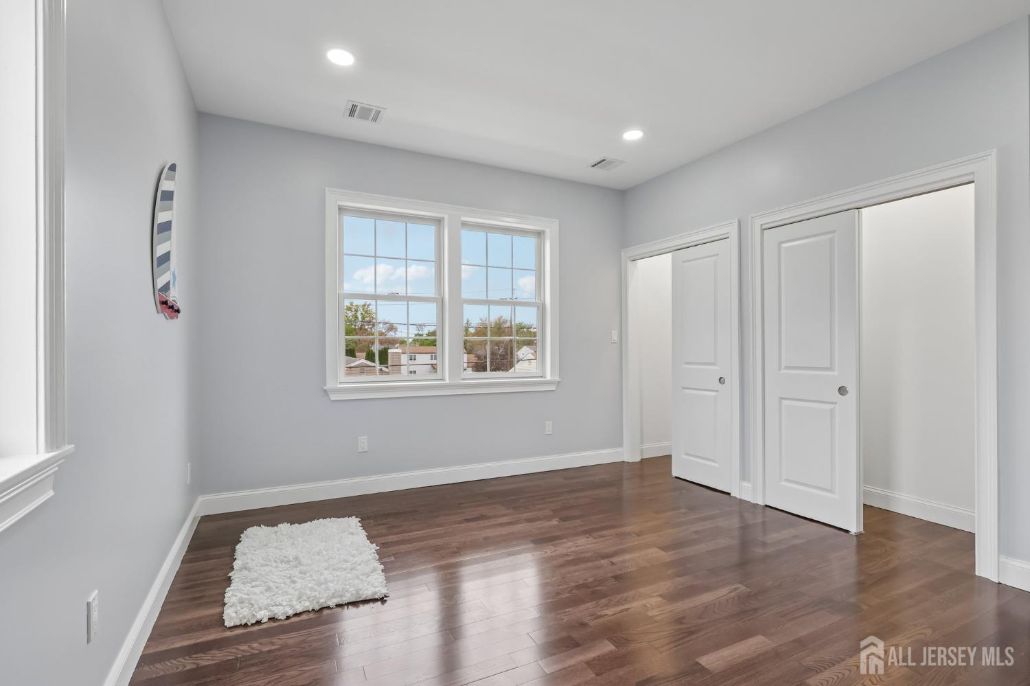 239 Suttons Lane Edison, NJ 08817 - Photo 54 of 68 an empty room with wooden floor and windows