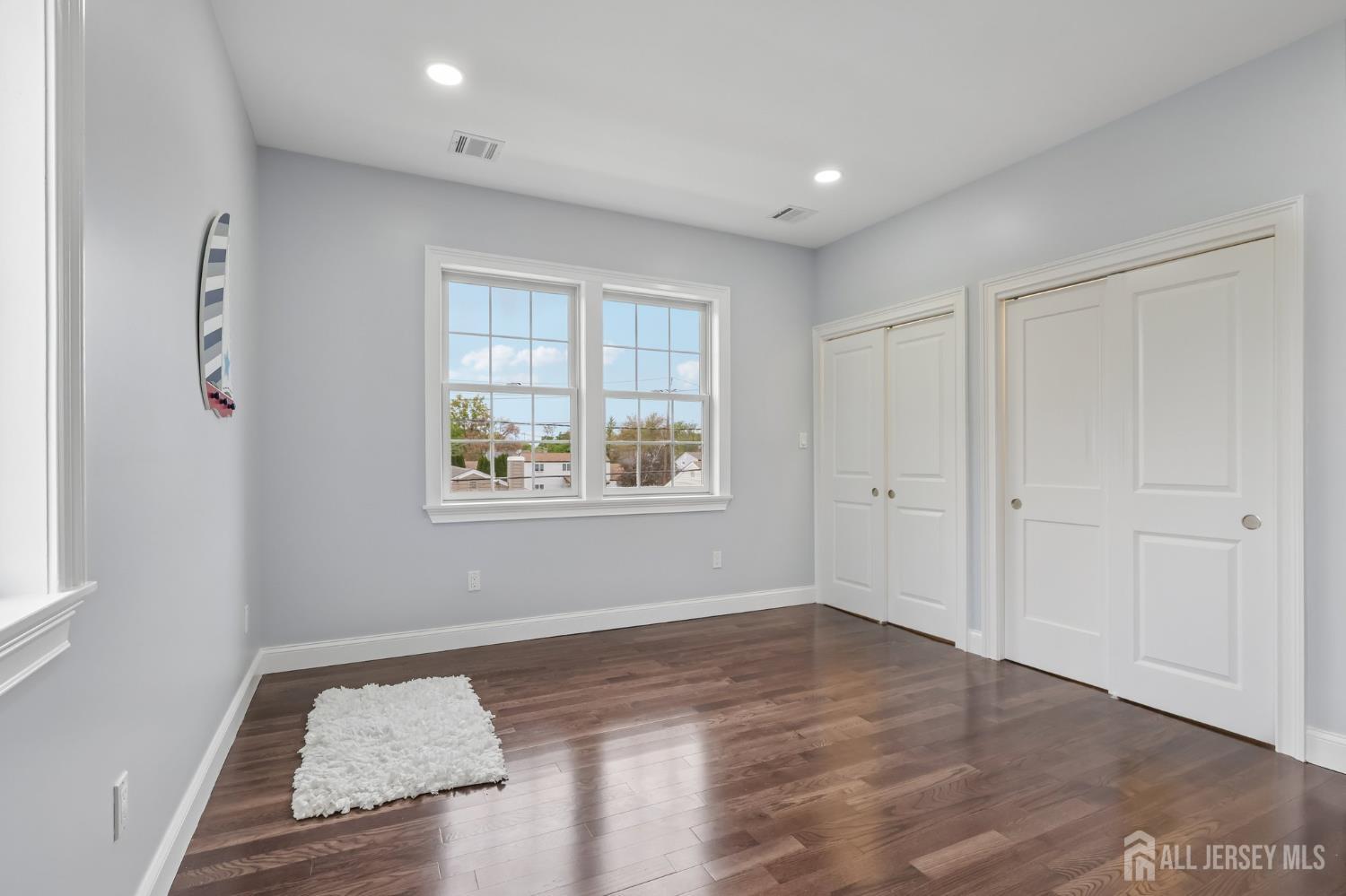 239 Suttons Lane Edison, NJ 08817 - Photo 55 of 68 an empty room with wooden floor and windows