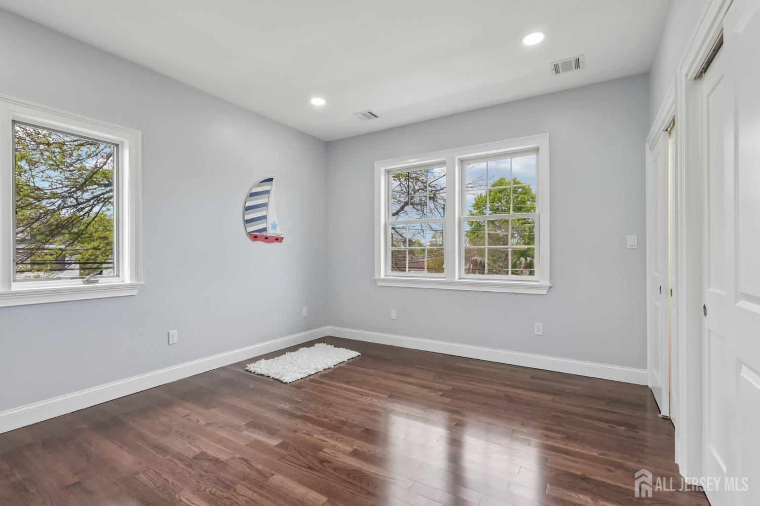239 Suttons Lane Edison, NJ 08817 - Photo 58 of 68 a view of an empty room with wooden floor and a window