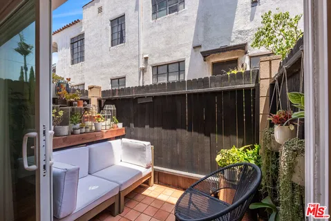 a view of a balcony with chairs and a potted plant