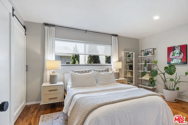 a bedroom with a bed and potted plant