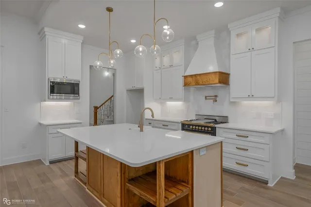 a kitchen with stainless steel appliances granite countertop a sink a stove a refrigerator and island