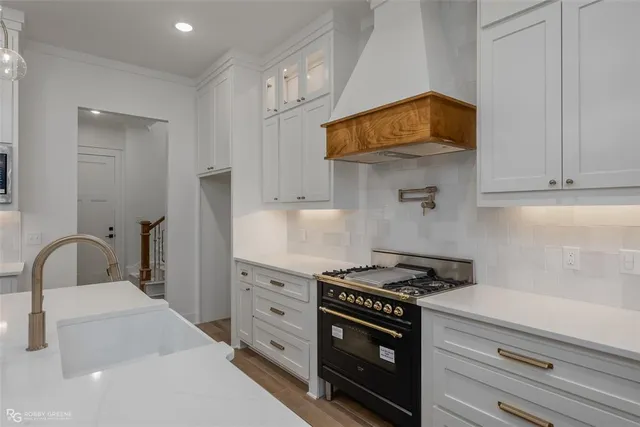a kitchen with stainless steel appliances granite countertop a stove and a sink