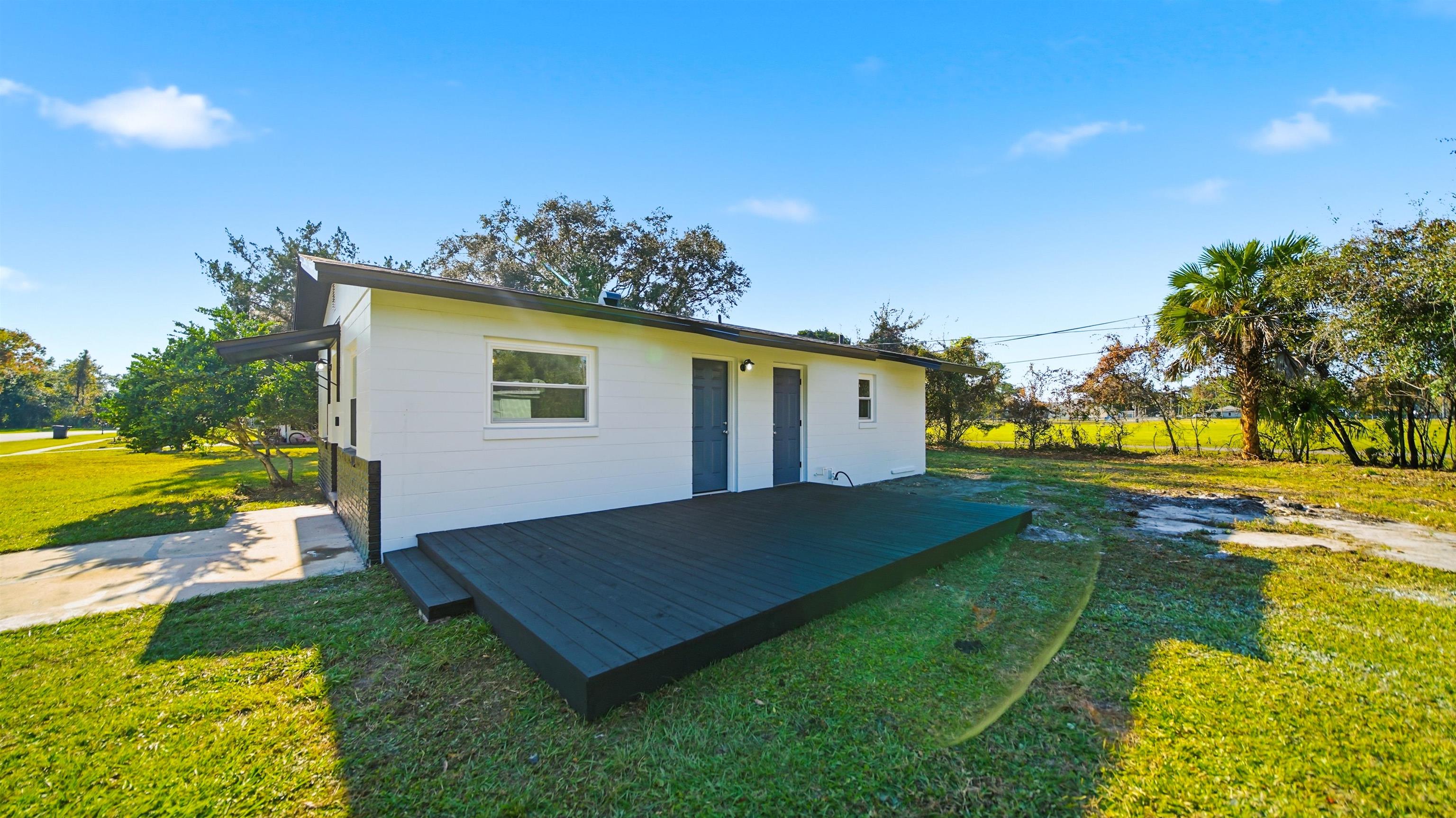 811 Hymon Circle Bunnell, FL 32110 - Photo 12 of 32 Rear view of property with a yard and a deck