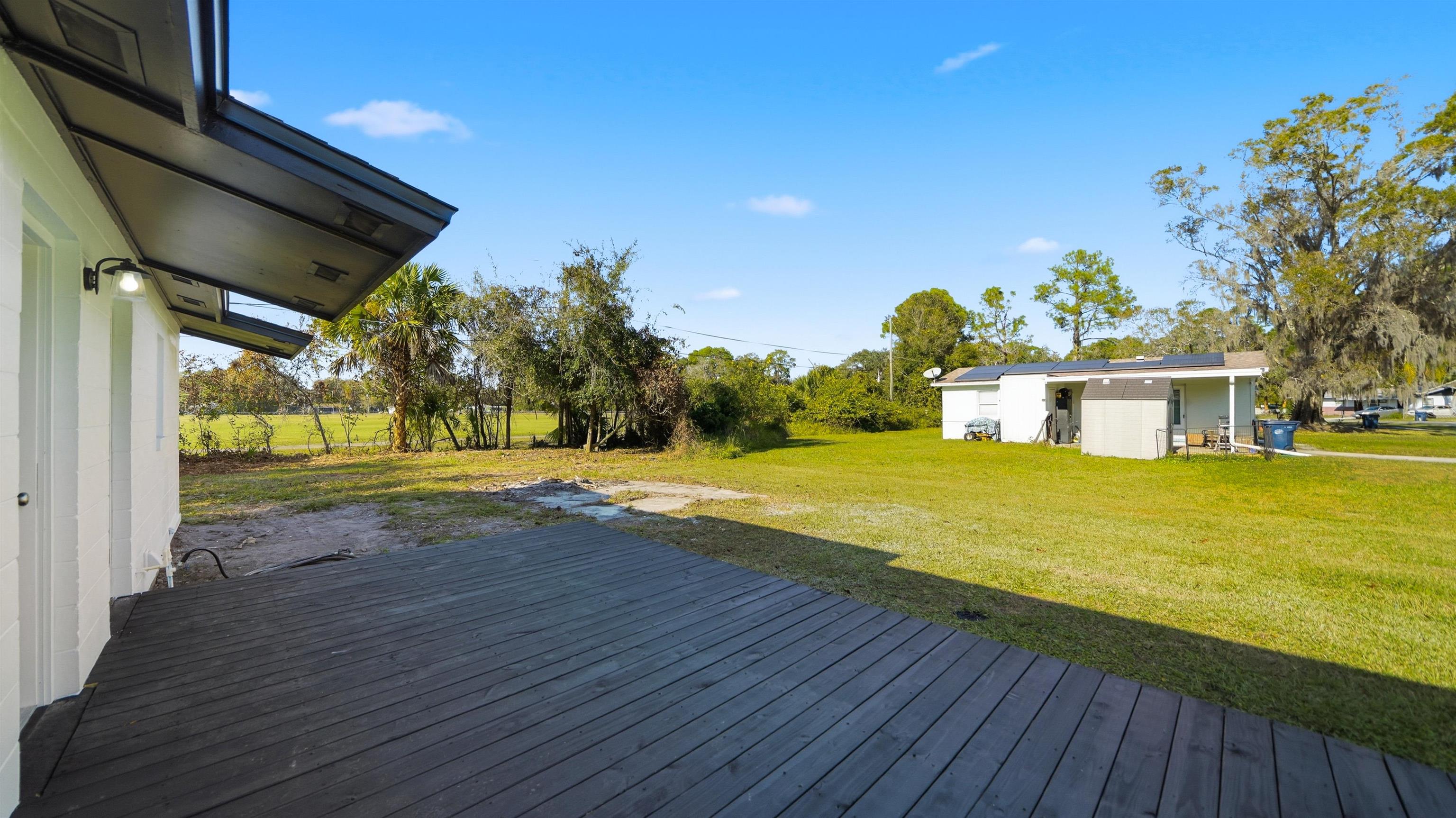 811 Hymon Circle Bunnell, FL 32110 - Photo 13 of 32 Wooden deck with a lawn