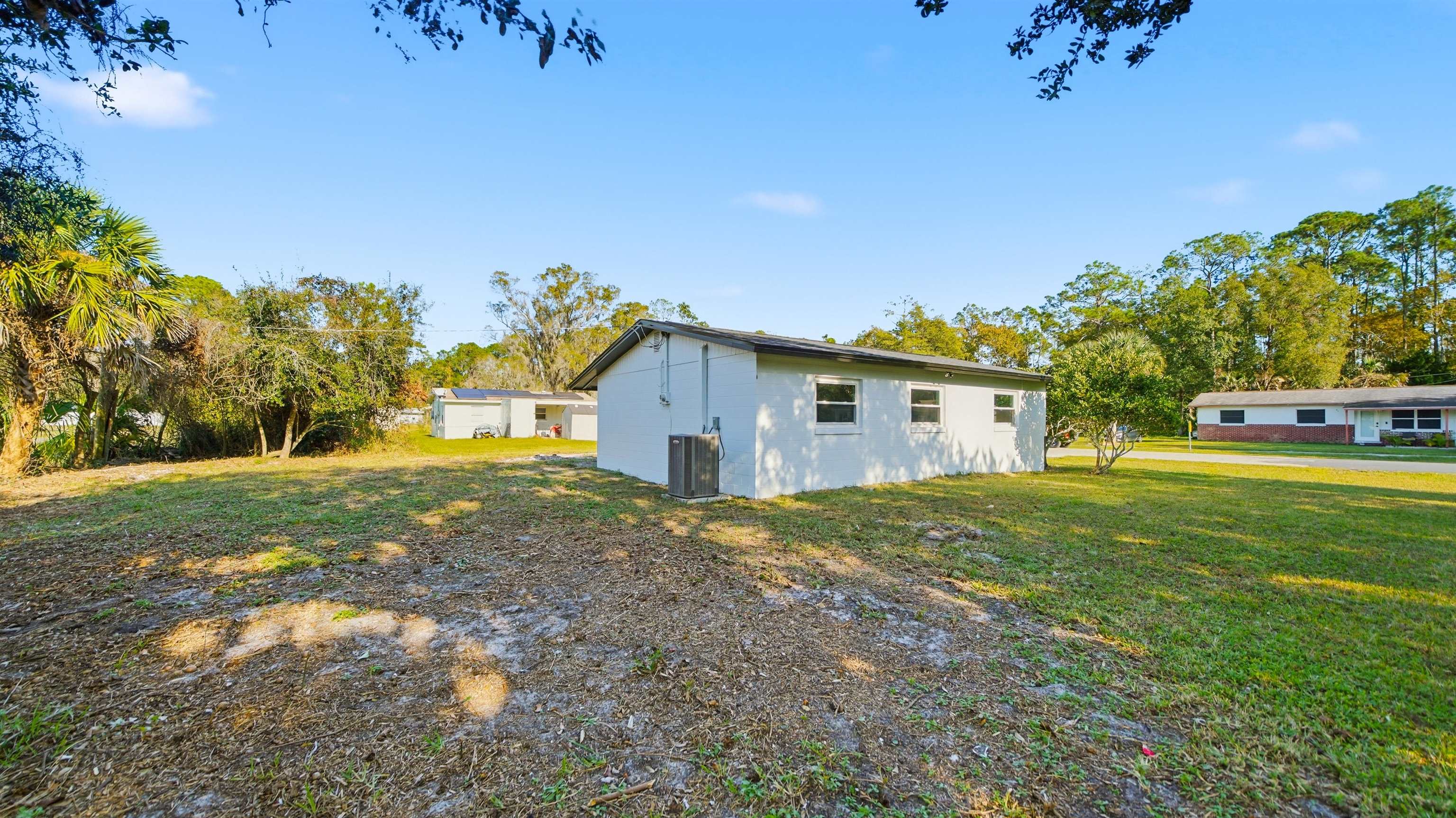 811 Hymon Circle Bunnell, FL 32110 - Photo 16 of 32 View of side of property with a yard and stucco siding