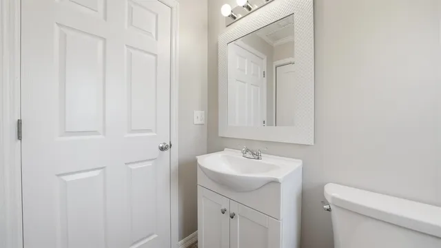 a bathroom with a sink a toilet and a mirror