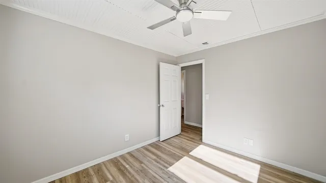 an empty room with a ceiling fan and carpet