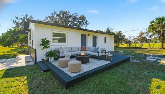 a view of a house with backyard sitting area and garden