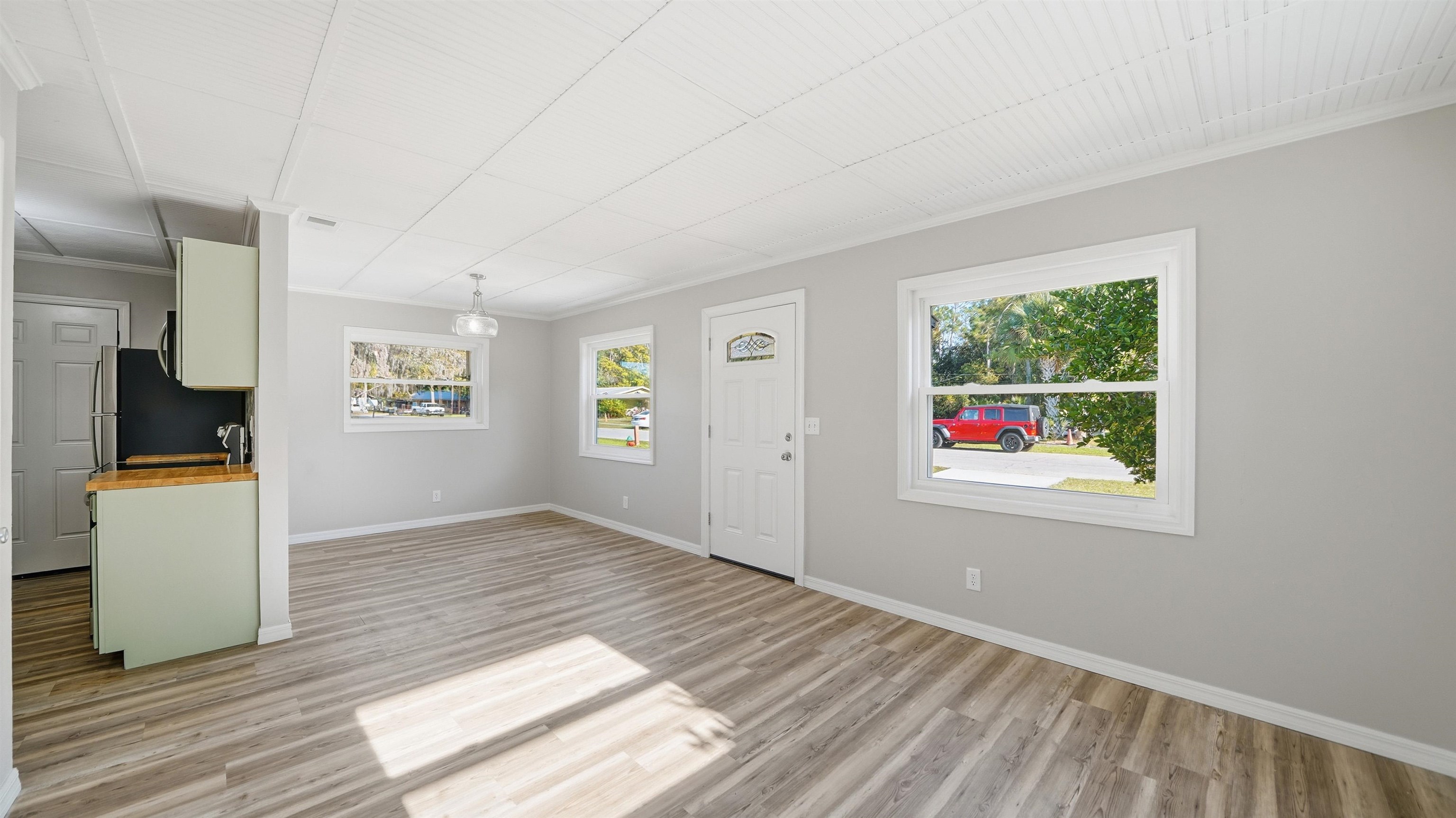 811 Hymon Circle Bunnell, FL 32110 - Photo 21 of 32 Unfurnished living room featuring crown molding and light wood-style floors