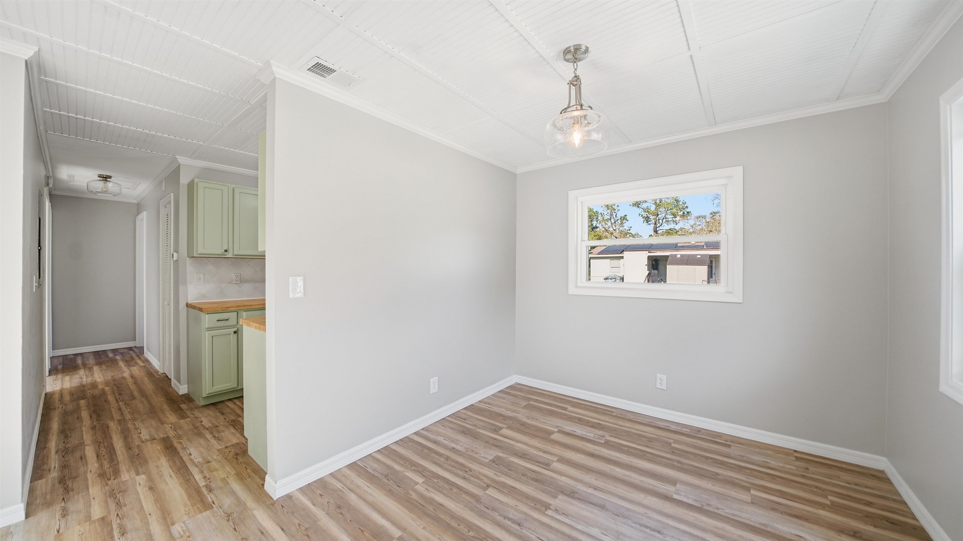 811 Hymon Circle Bunnell, FL 32110 - Photo 22 of 32 Unfurnished dining area featuring light wood-style flooring and ornamental molding