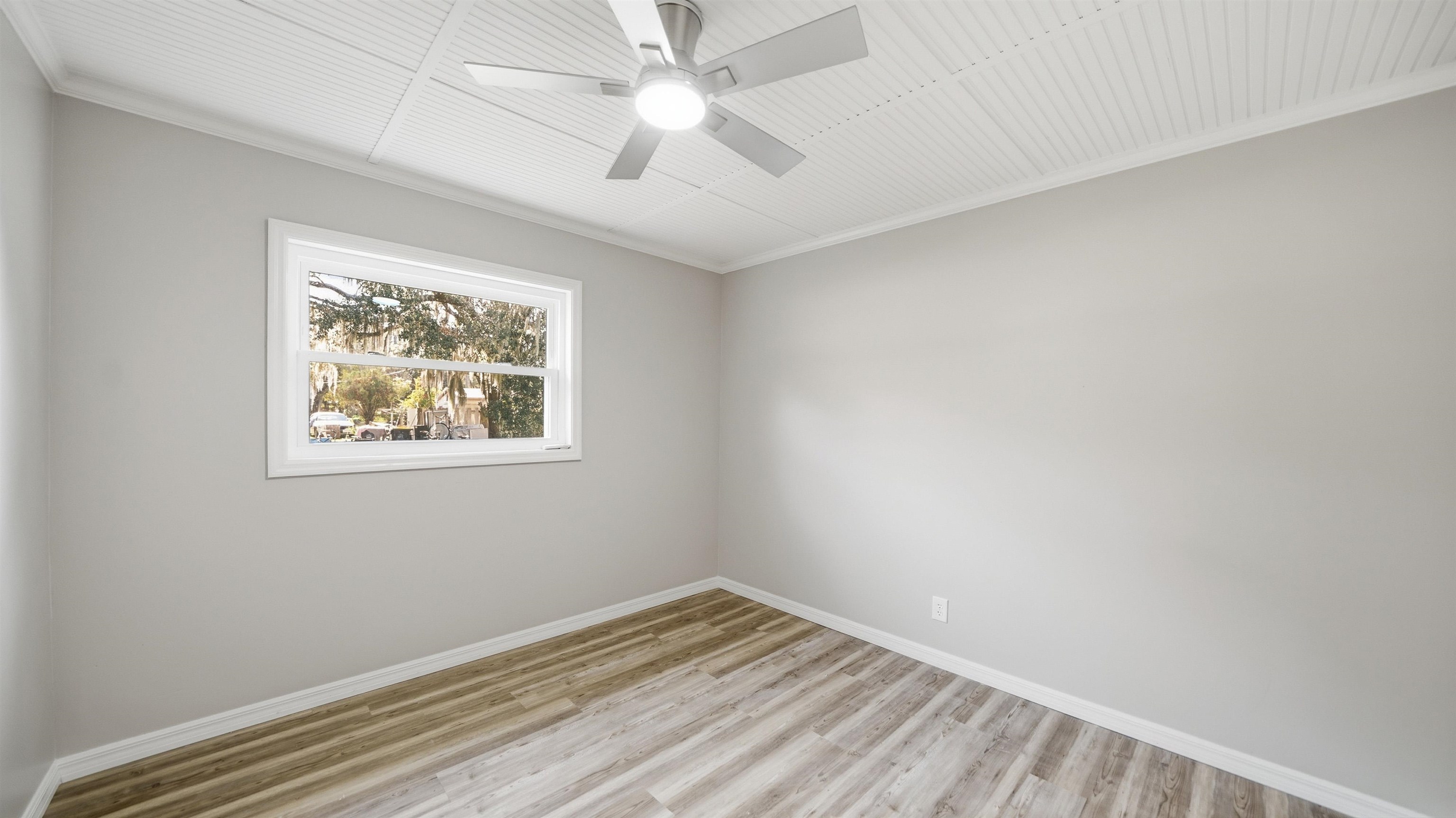 811 Hymon Circle Bunnell, FL 32110 - Photo 3 of 32 Spare room featuring ornamental molding, light wood-style floors, and a ceiling fan