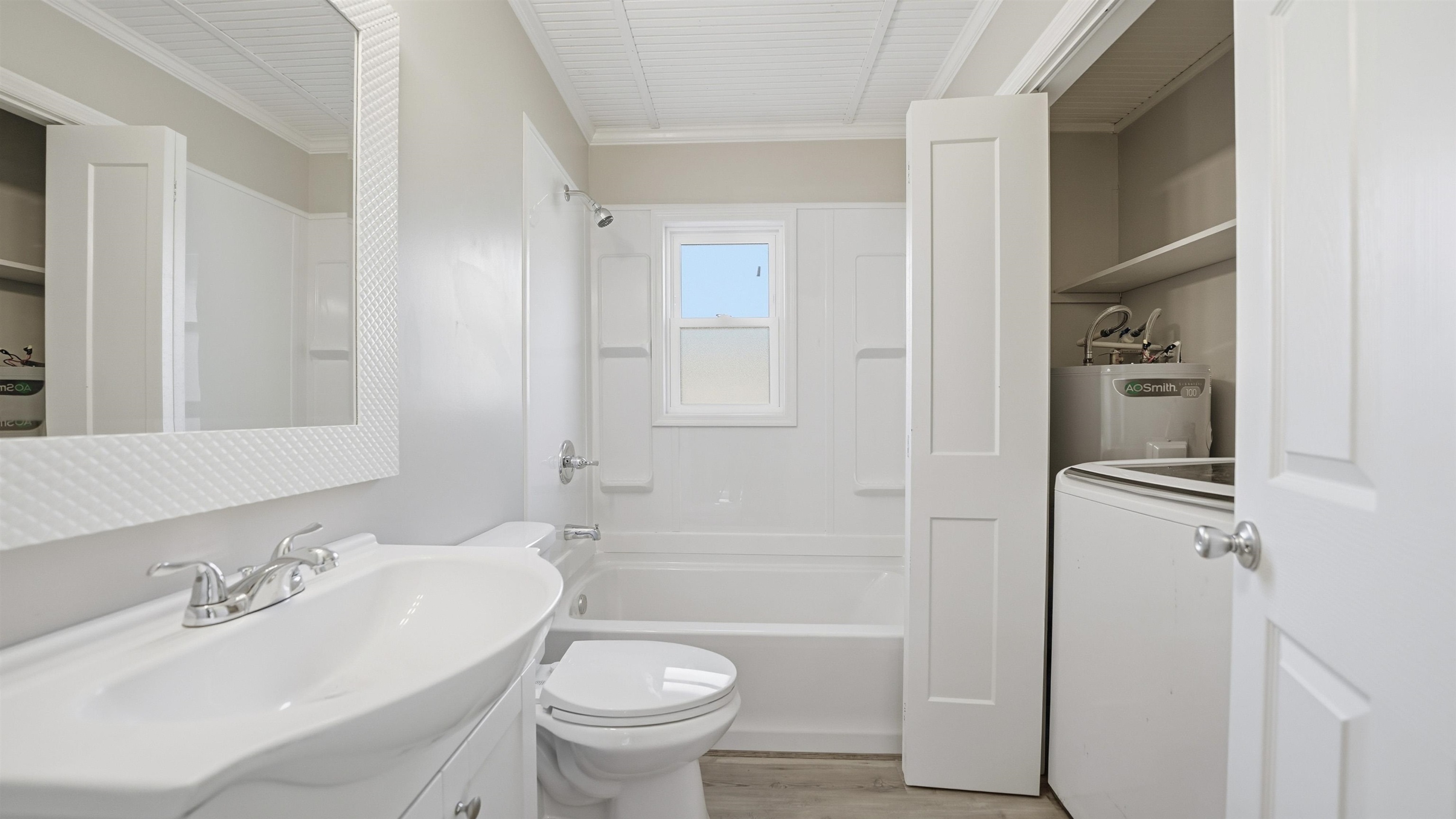 811 Hymon Circle Bunnell, FL 32110 - Photo 6 of 32 Full bath with washer / clothes dryer, electric water heater, vanity, shower combination, and crown molding