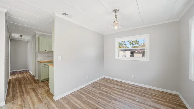 a view of empty room with wooden floor and window