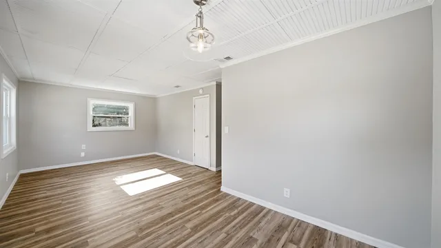 wooden floor in an empty room with a window