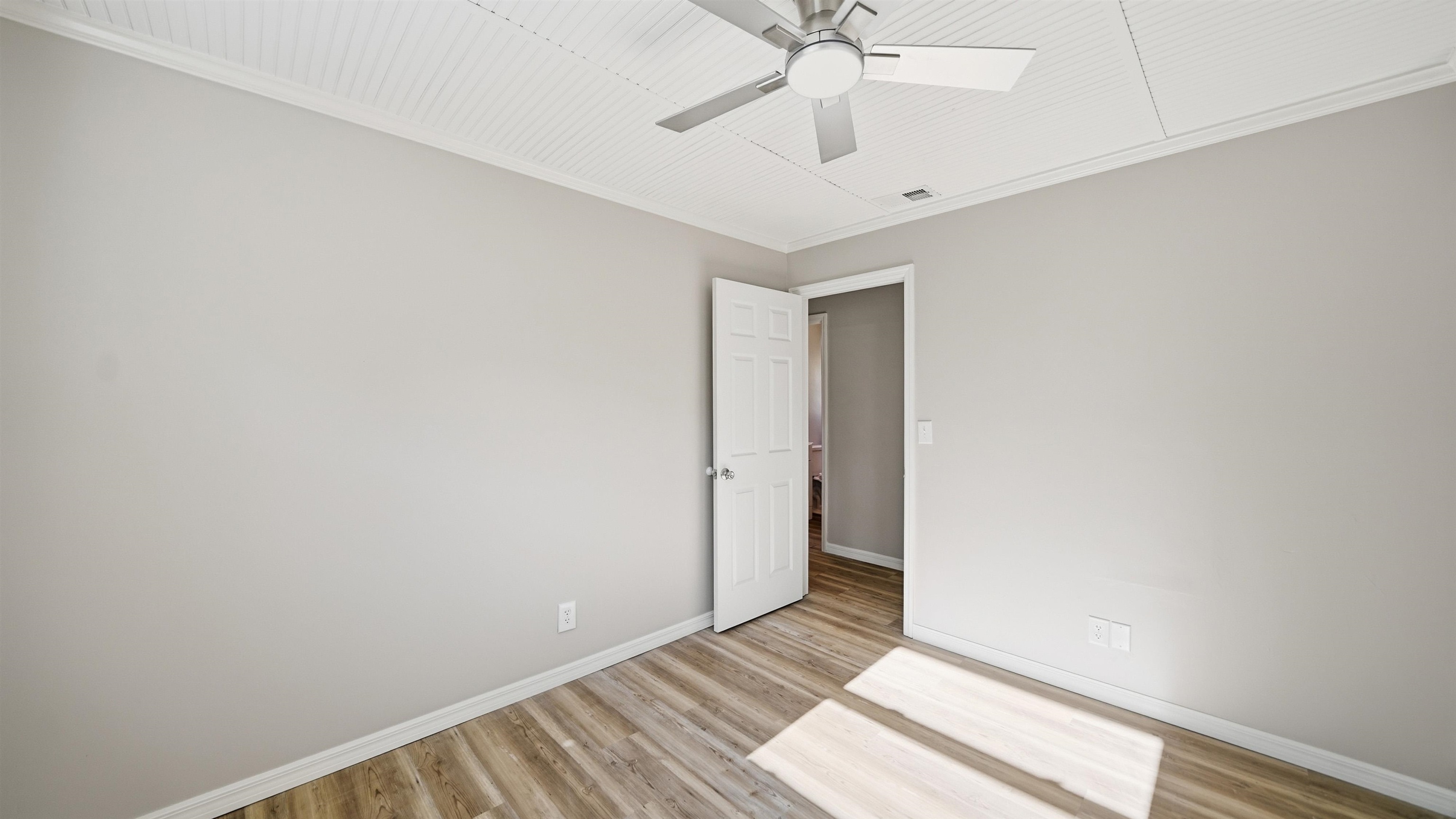 811 Hymon Circle Bunnell, FL 32110 - Photo 10 of 32 Unfurnished bedroom with crown molding, light wood-style flooring, and ceiling fan
