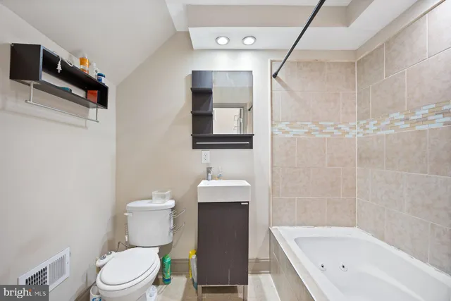 a bathroom with a white bath tub sitting next to a white sink and a shower