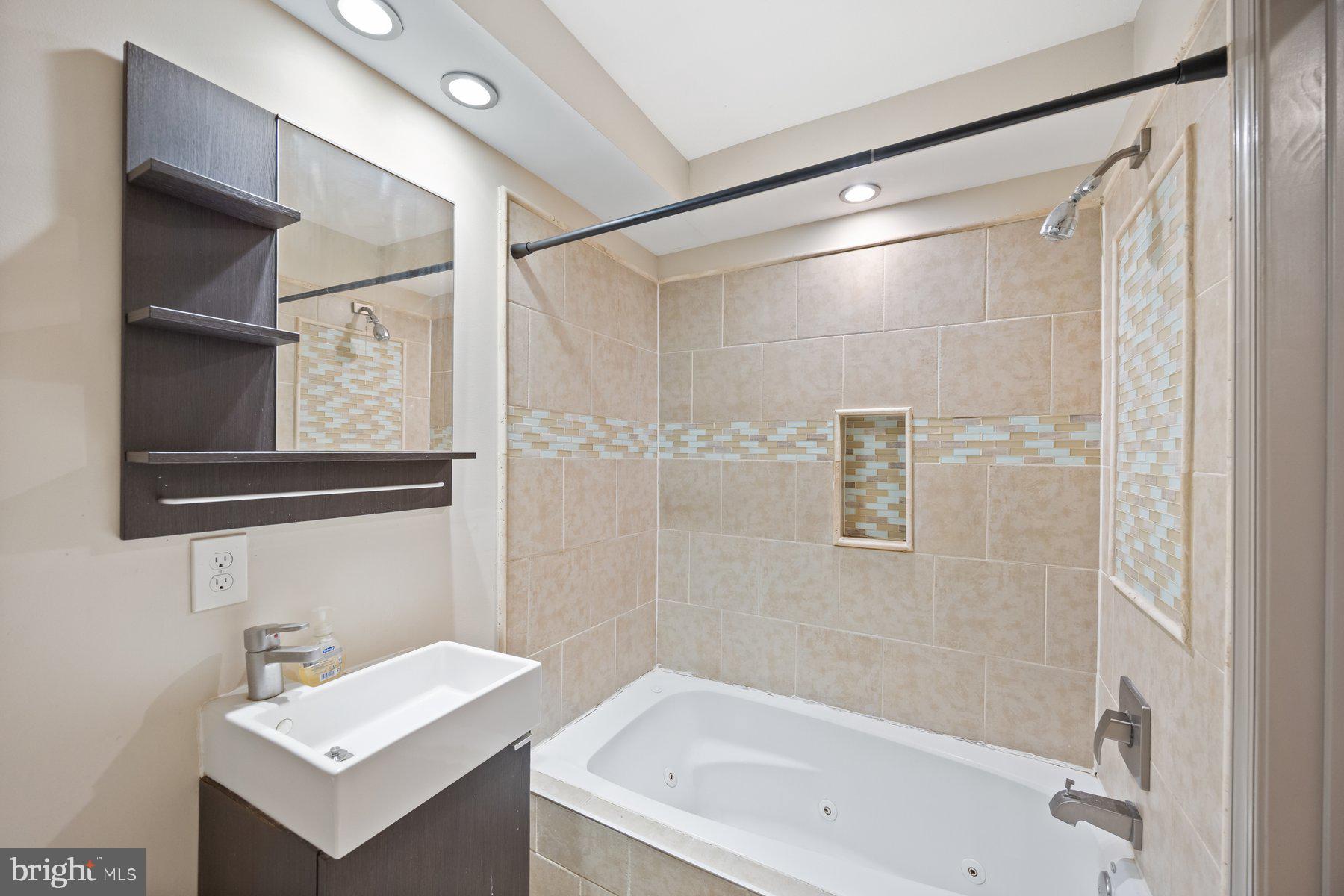 2209 Mullikin Street Baltimore, MD 21231 - Photo 14 of 32 a bathroom with a white bath tub sitting next to a white sink and a shower