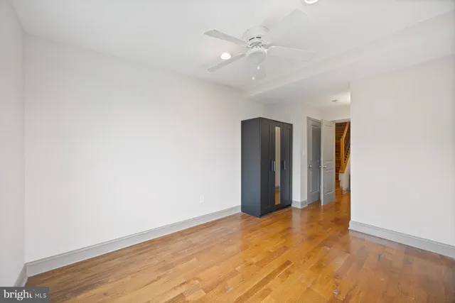 a view of an empty room with window and wooden floor