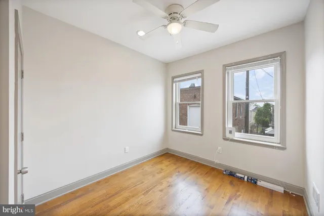 a view of a livingroom with wooden floor and a bathroom