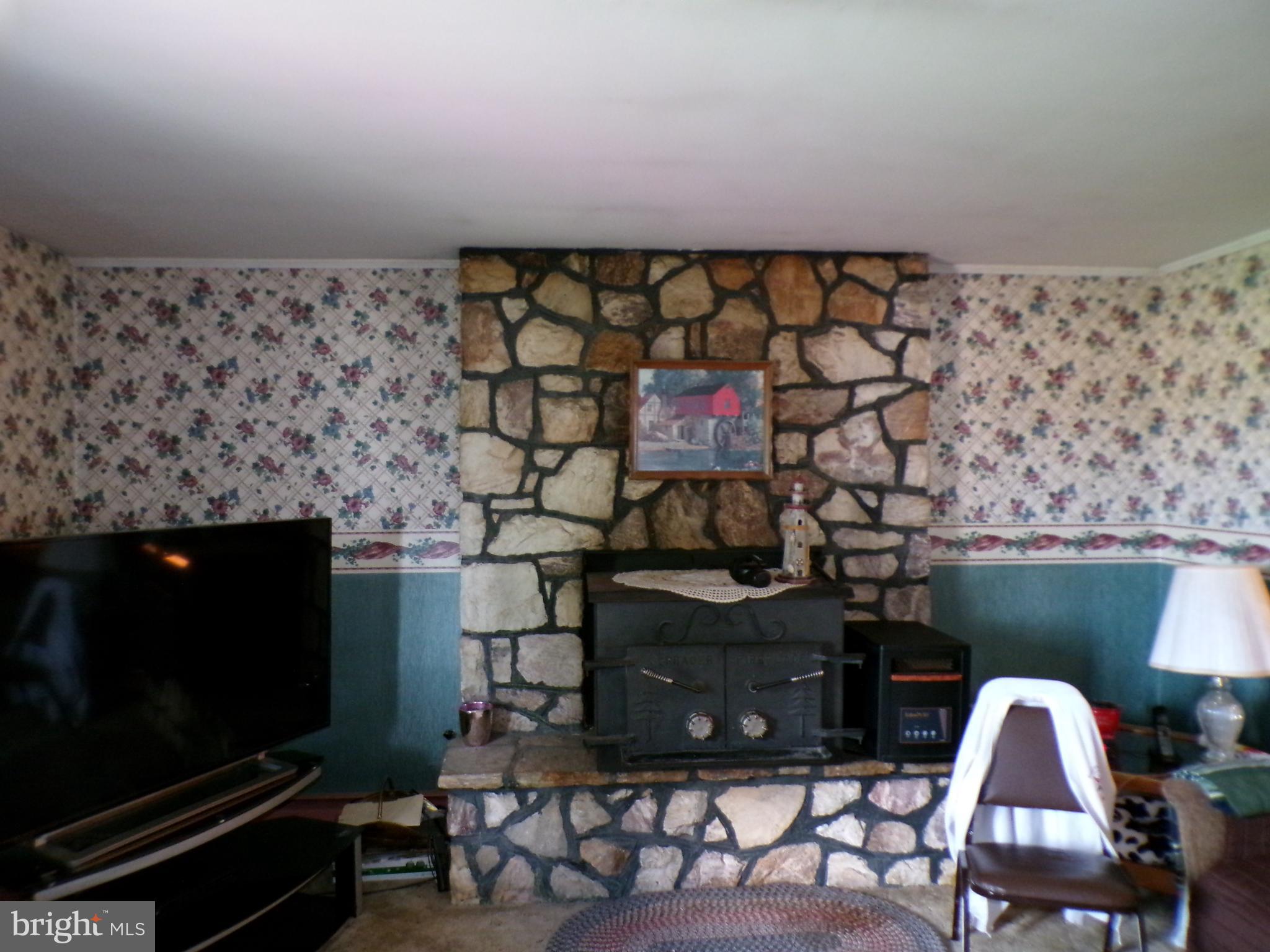 2713 Rowe Road New Windsor, MD 21776 - Photo 19 of 67 a living room with a fireplace and a flat screen tv