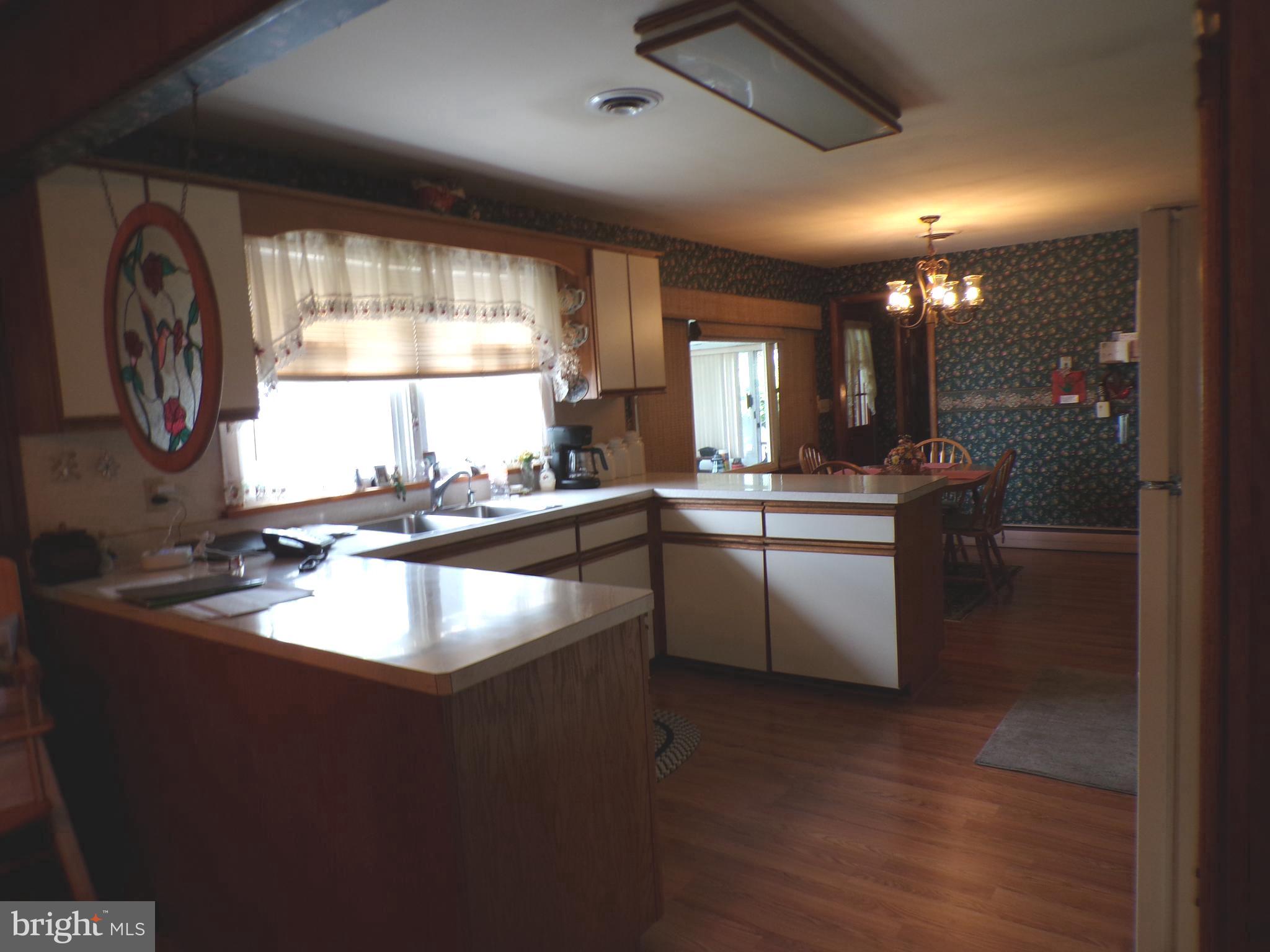 2713 Rowe Road New Windsor, MD 21776 - Photo 21 of 67 a kitchen with kitchen island granite countertop a sink appliances cabinets and a large window
