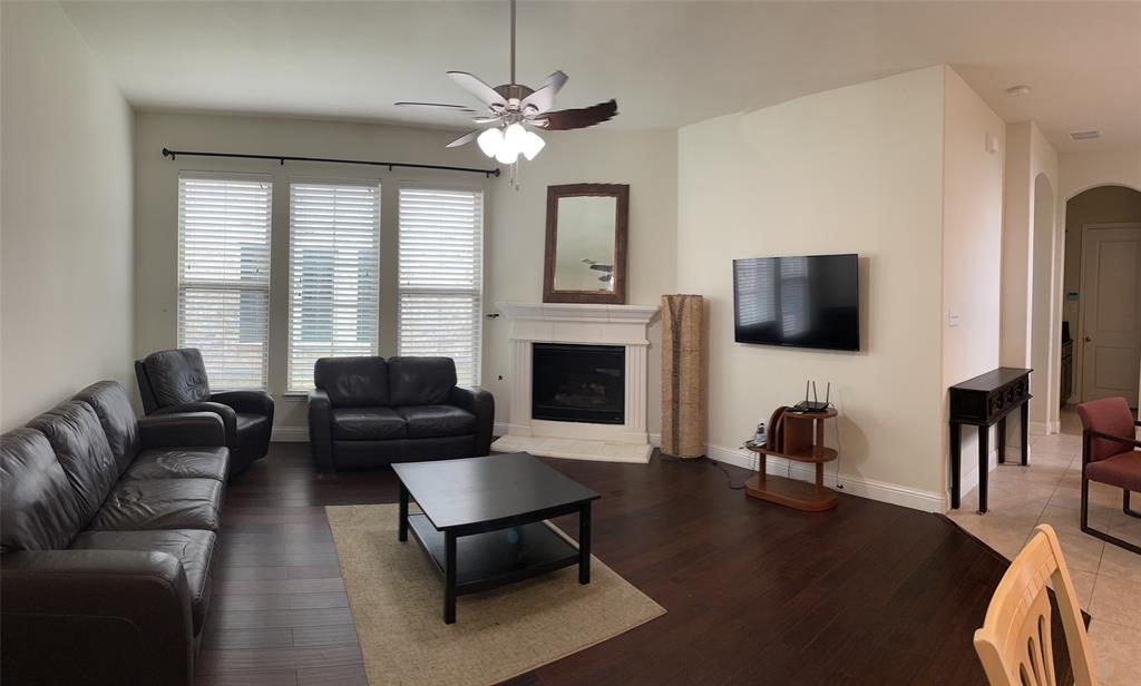 8031 Sunflower Lane Dallas, TX 75252 - Photo 13 of 34 a living room with furniture a fireplace and a flat screen tv