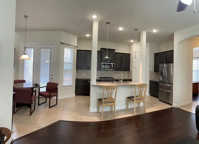 a kitchen with granite countertop a sink dishwasher stove and cabinets