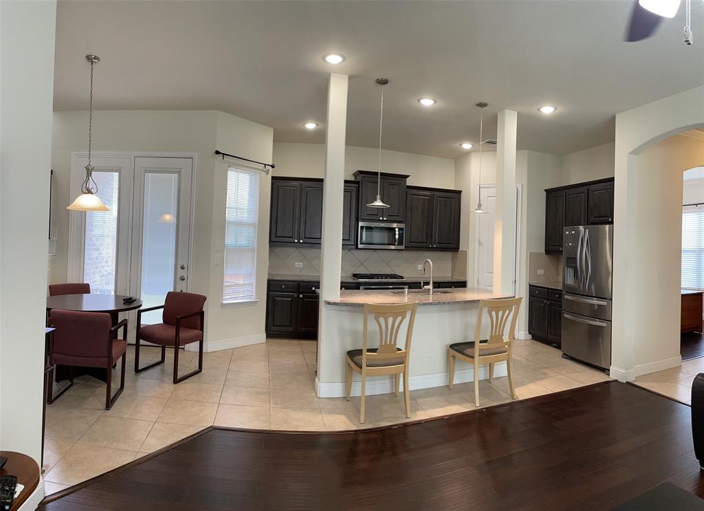 8031 Sunflower Lane Dallas, TX 75252 - Photo 14 of 34 a large kitchen with a table and stainless steel appliances