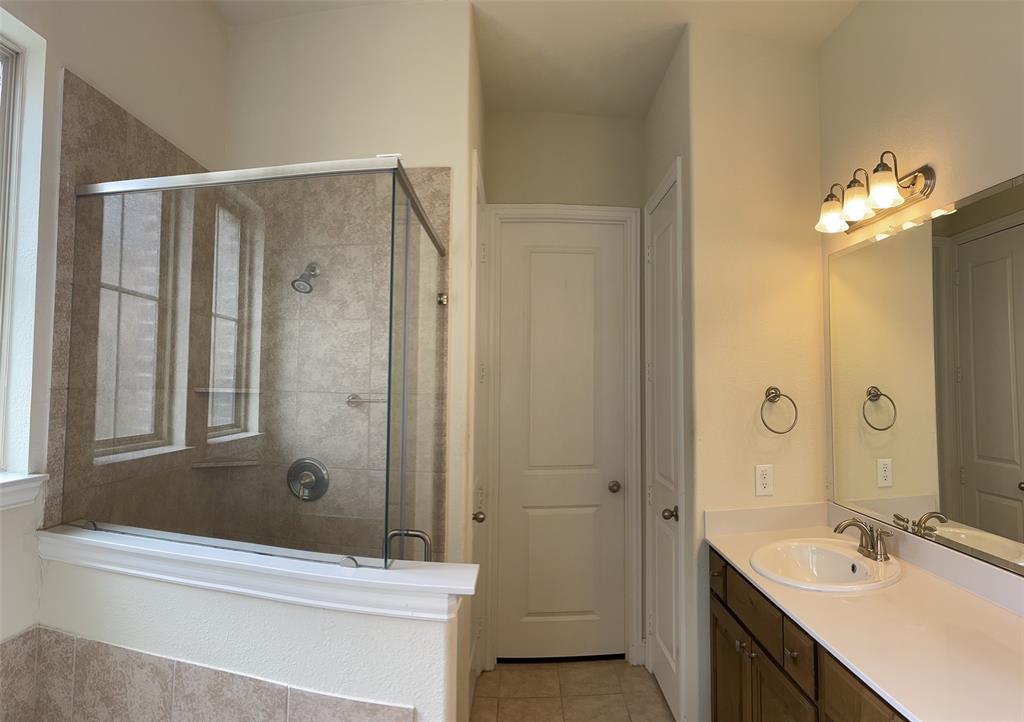 8031 Sunflower Lane Dallas, TX 75252 - Photo 21 of 34 a bathroom with a tub shower sink and mirror