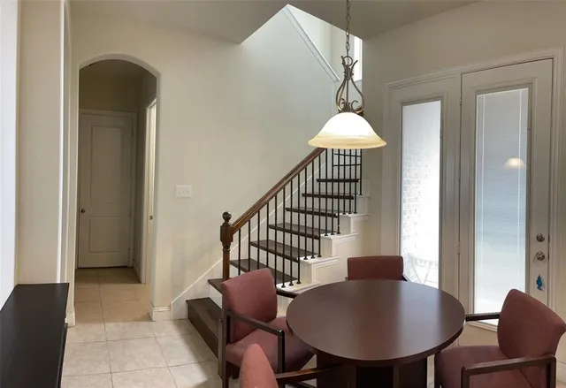 an empty room with wooden floor chandelier fan and windows