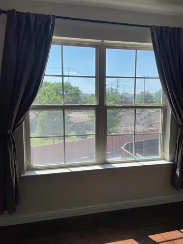 an empty room with a window and a ceiling fan