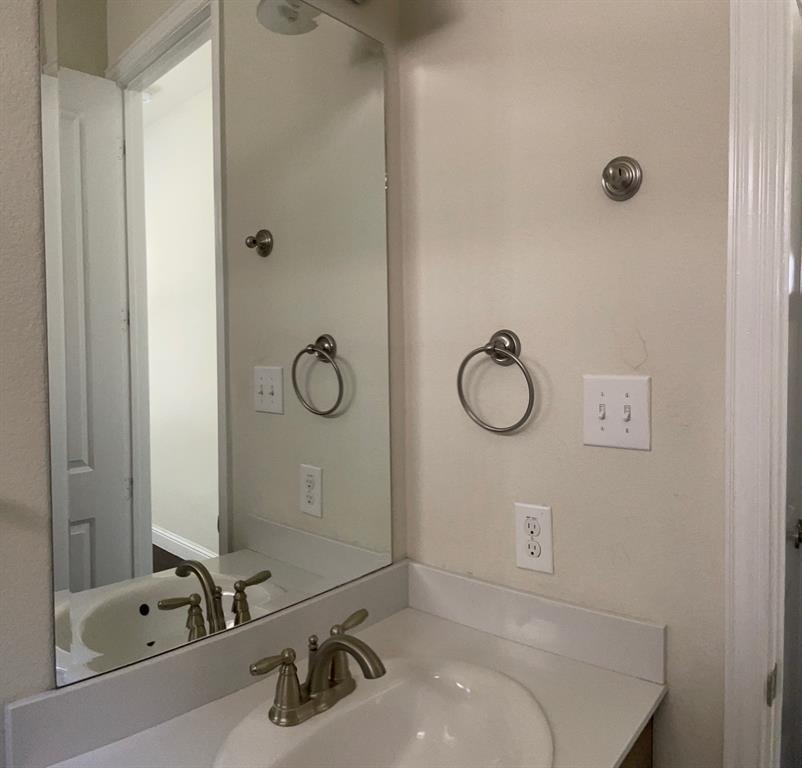 8031 Sunflower Lane Dallas, TX 75252 - Photo 32 of 34 a bathroom with a sink and a mirror