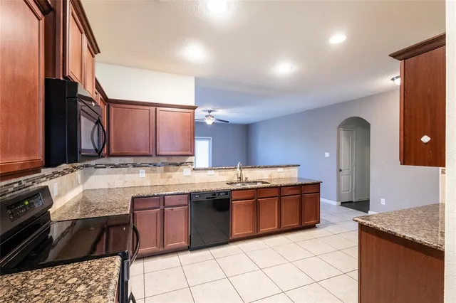 a kitchen with granite countertop cabinets stainless steel appliances and a counter space