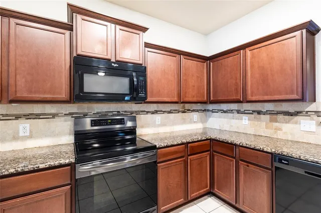 a kitchen with granite countertop a sink stainless steel appliances and cabinets