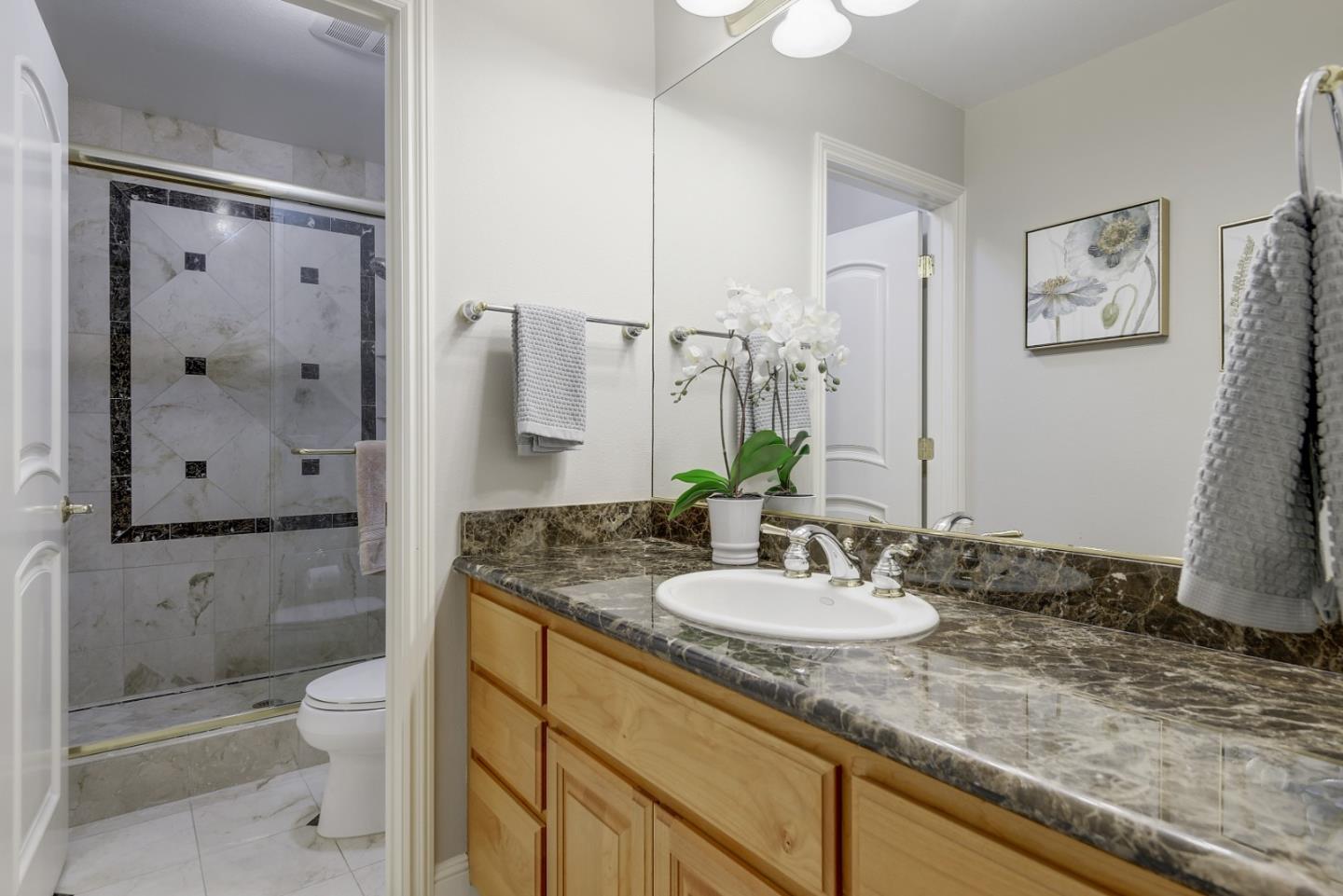 928 Wright Avenue, Unit 401 Mountain View, CA 94043 - Photo 16 of 18 a bathroom with a granite countertop sink toilet and shower