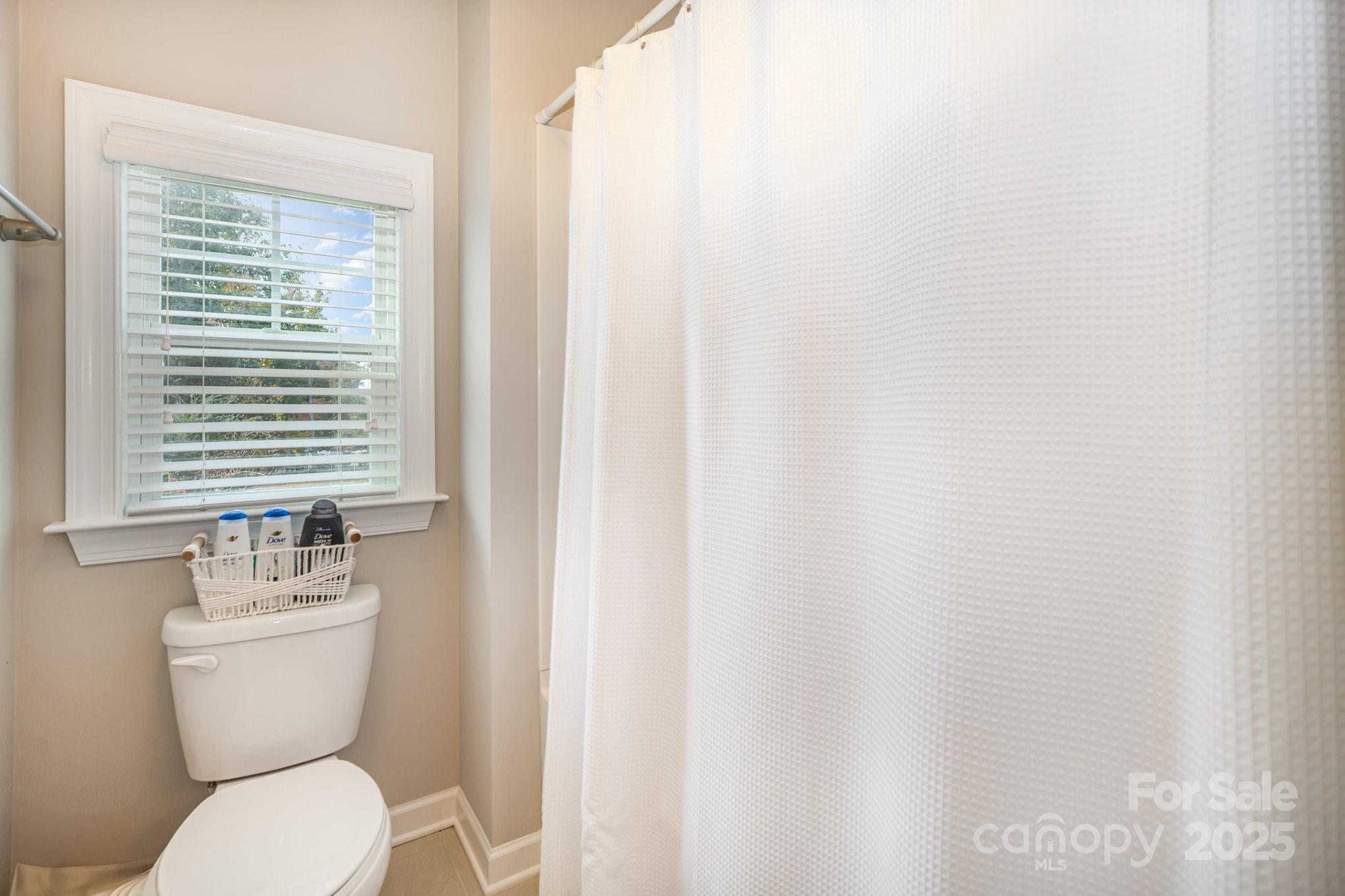 1556 Prickly Lane Waxhaw, NC 28173 - Photo 24 of 39 a bathroom with a toilet a sink and a window