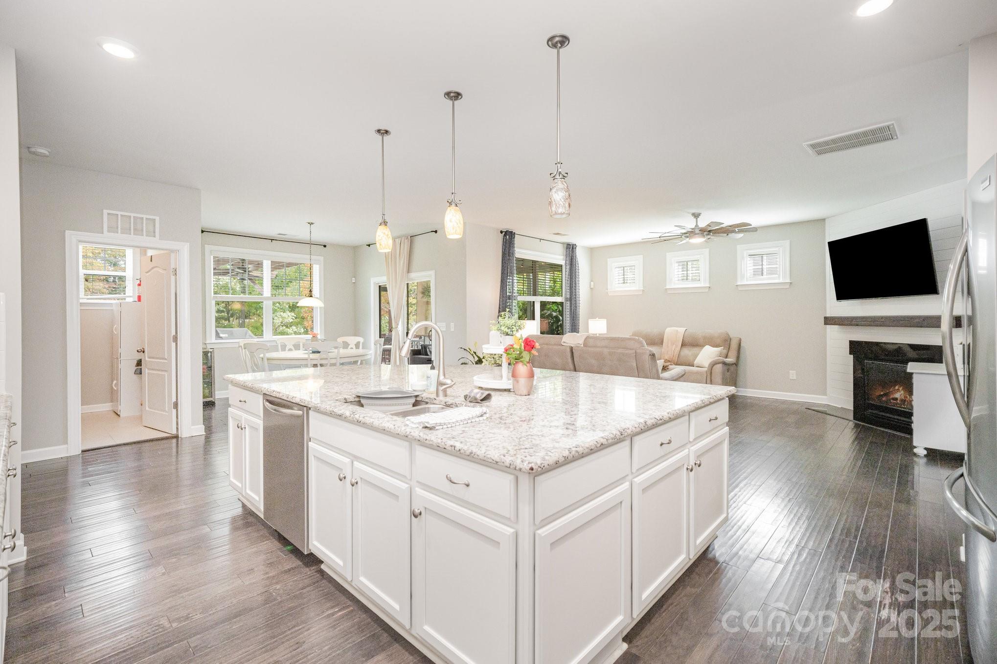 1556 Prickly Lane Waxhaw, NC 28173 - Photo 5 of 39 a large kitchen with kitchen island a sink dishwasher a stove a dining table and chairs with wooden floor