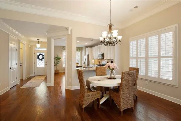 a dining room with furniture potted plants and wooden floor