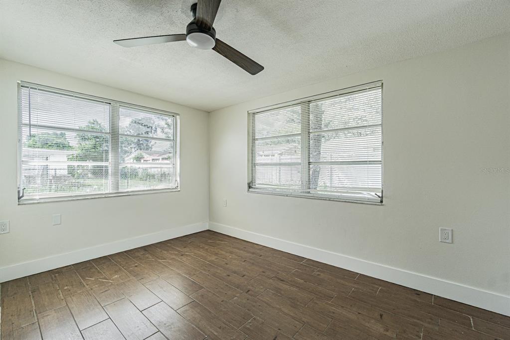 5631 Riddle Road Holiday, FL 34690 - Photo 12 of 27 a view of empty room with wooden floor and fan