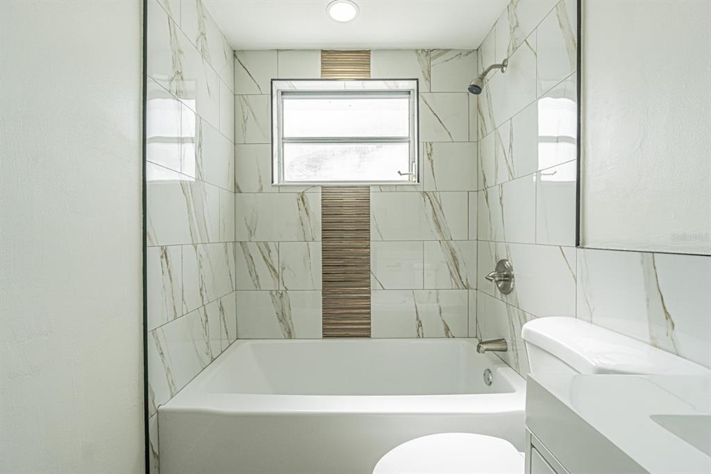 5631 Riddle Road Holiday, FL 34690 - Photo 14 of 27 a bathroom with a bathtub and window